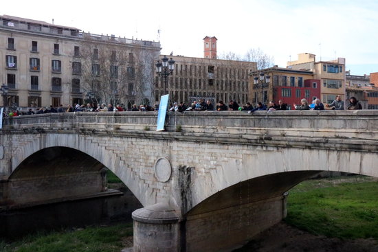 Omplen el riu Onyar, afluent del riu Ter, amb galledes d'aigua al Pont de Pedra de Girona