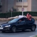 Circula amb gent estirada al sostre d’un cotxe en una rotonda de Palafrugell Condueixen amb gent estirada al sostre del cotxe a Palafrugell