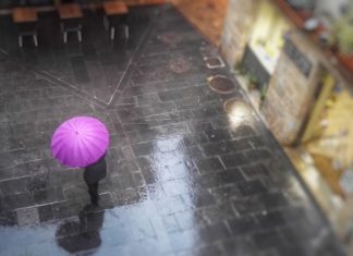 Protecció Civil manté l’alerta per pluges intenses a les comarques gironines Persona sota un paraigües rosa a la Bisbal d'Empordà ruixat xafec