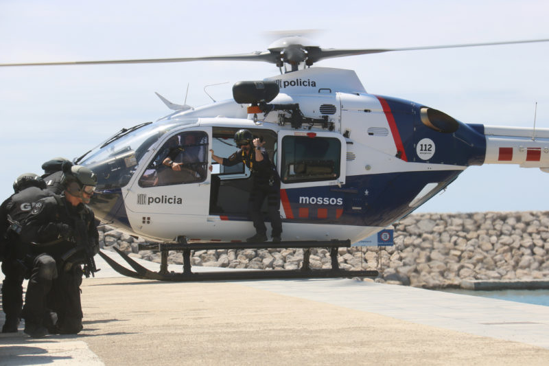 Agents dels GEI al costat d'un helicòpter dels Mossos durant la presentació de la consolidació de la Unitat de Policia Marítima - Albert Segura/ACN