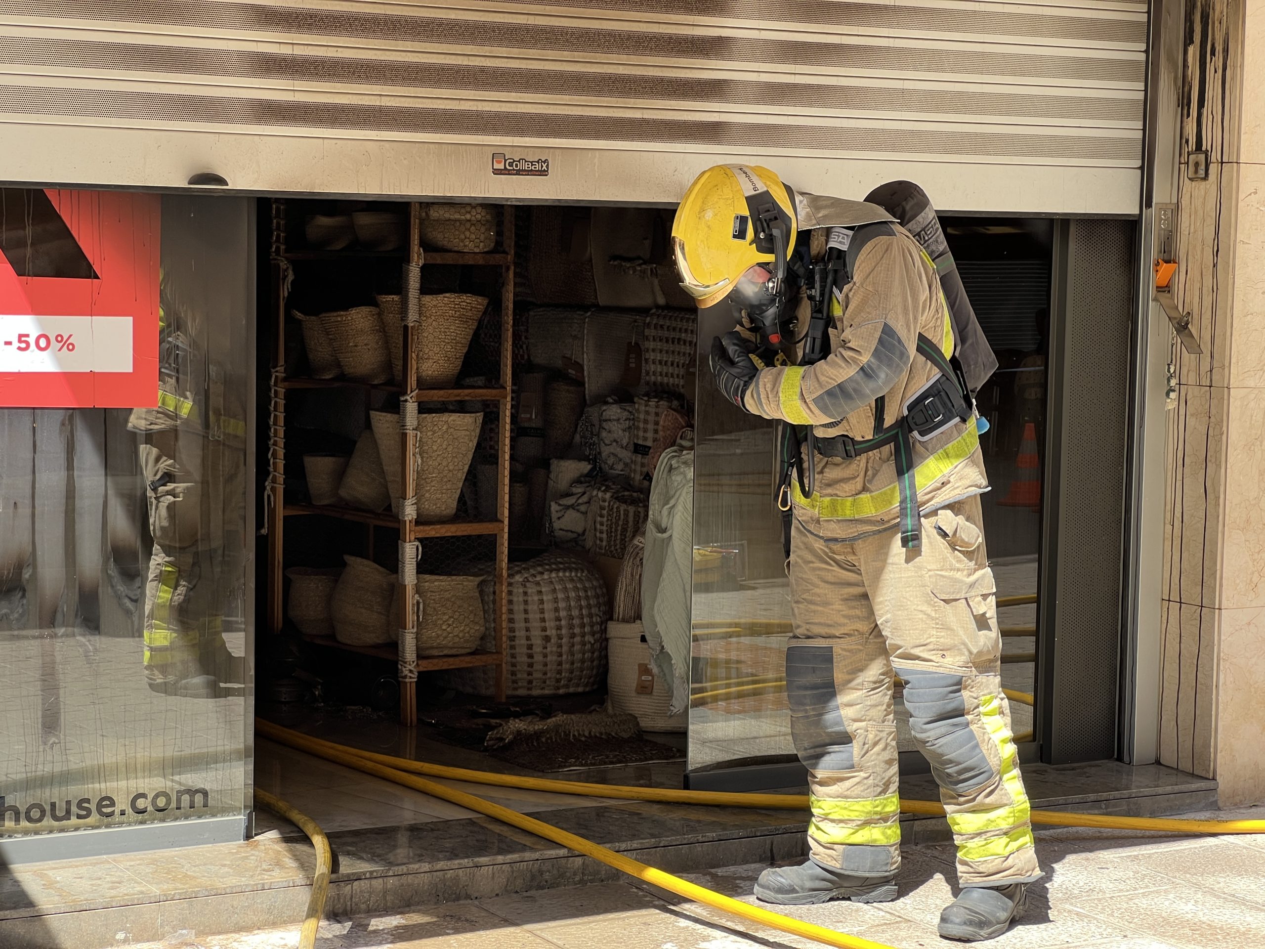 Els bombers davant d'una botiga que ha cremat al centre de Palafrugelll | Imatge de Gerard Escaich Folch