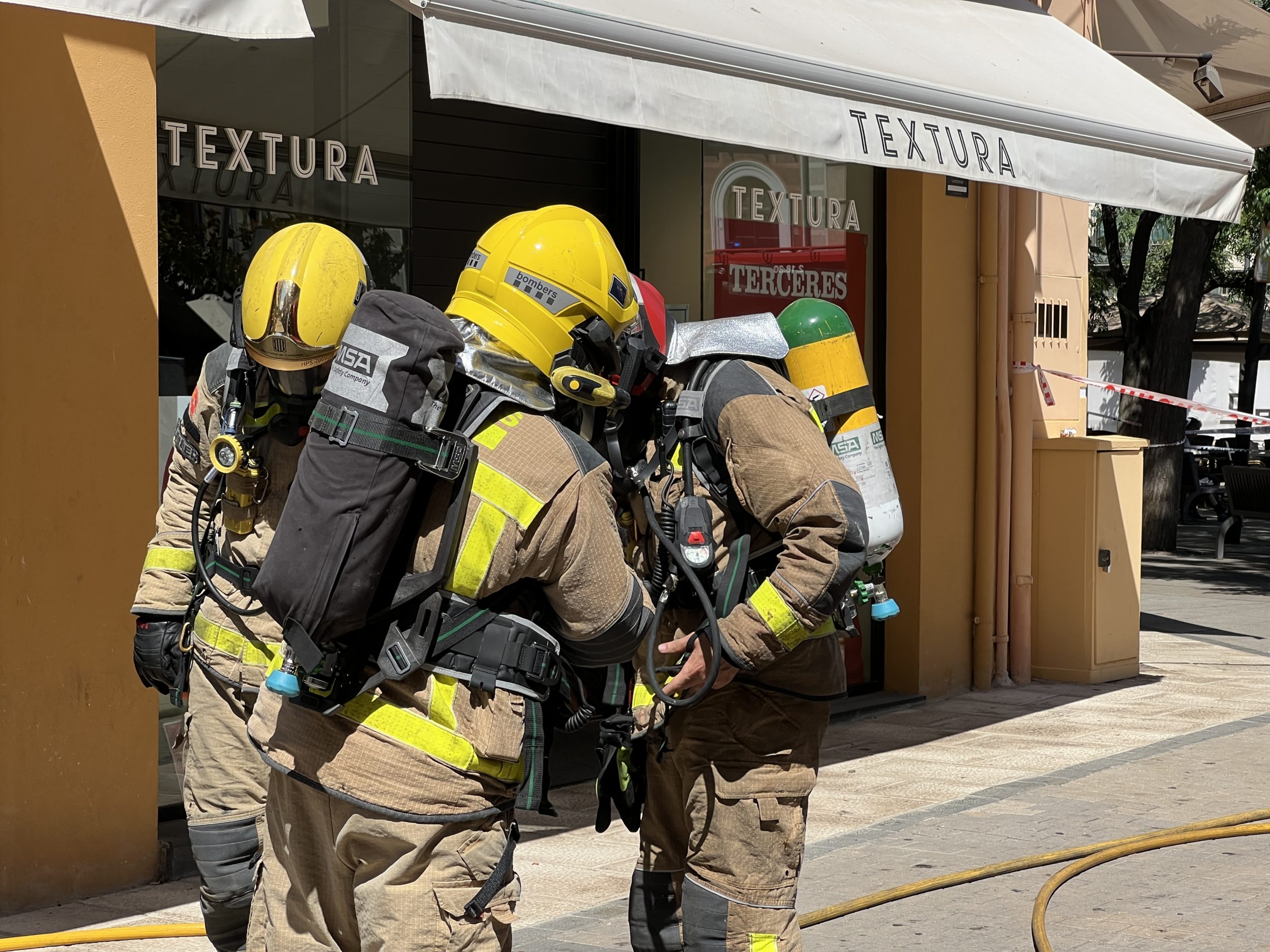 Els bombers davant d'una botiga que ha cremat al centre de Palafrugelll | Imatge de Gerard Escaich Folch