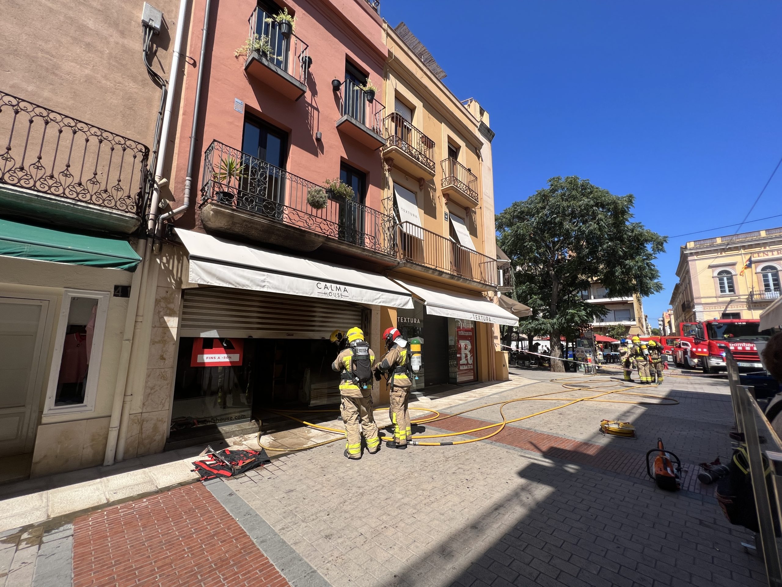 Els bombers davant d'una botiga que ha cremat al centre de Palafrugelll | Imatge de Gerard Escaich Folch