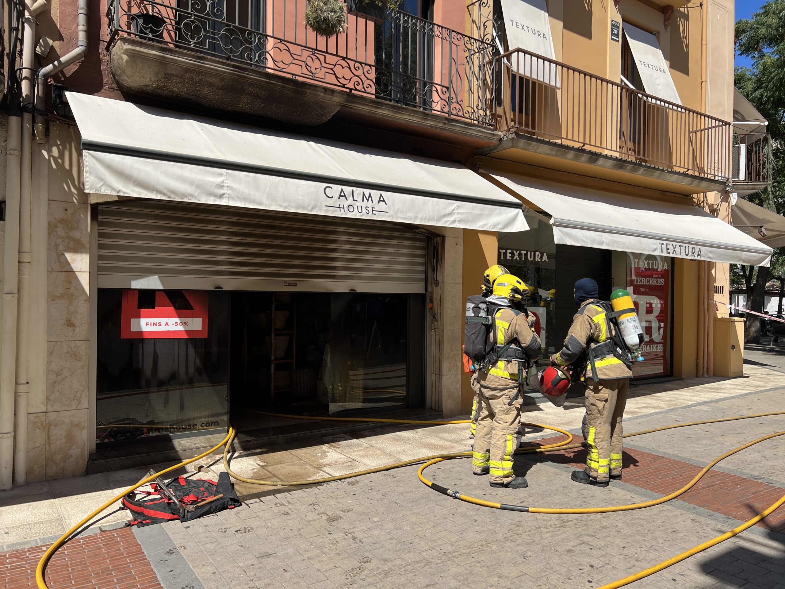 Els bombers davant d'una botiga que ha cremat al centre de Palafrugelll | Imatge de Gerard Escaich Folch