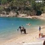 Un home es passeja a cavall per la platja de Tamariu Un senyor passejant-se amb un cavall a Tamariu | @enriccanela