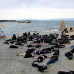 Ecologistes i veïns simulen un mar ple de peixos i aus mortes com a protesta contra el parc eòlic marí de Roses