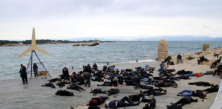 Ecologistes i veïns simulen un mar ple de peixos i aus mortes com a protesta contra el parc eòlic marí de Roses
