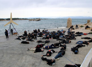 Ecologistes i veïns simulen un mar ple de peixos i aus mortes com a protesta contra el parc eòlic marí de Roses